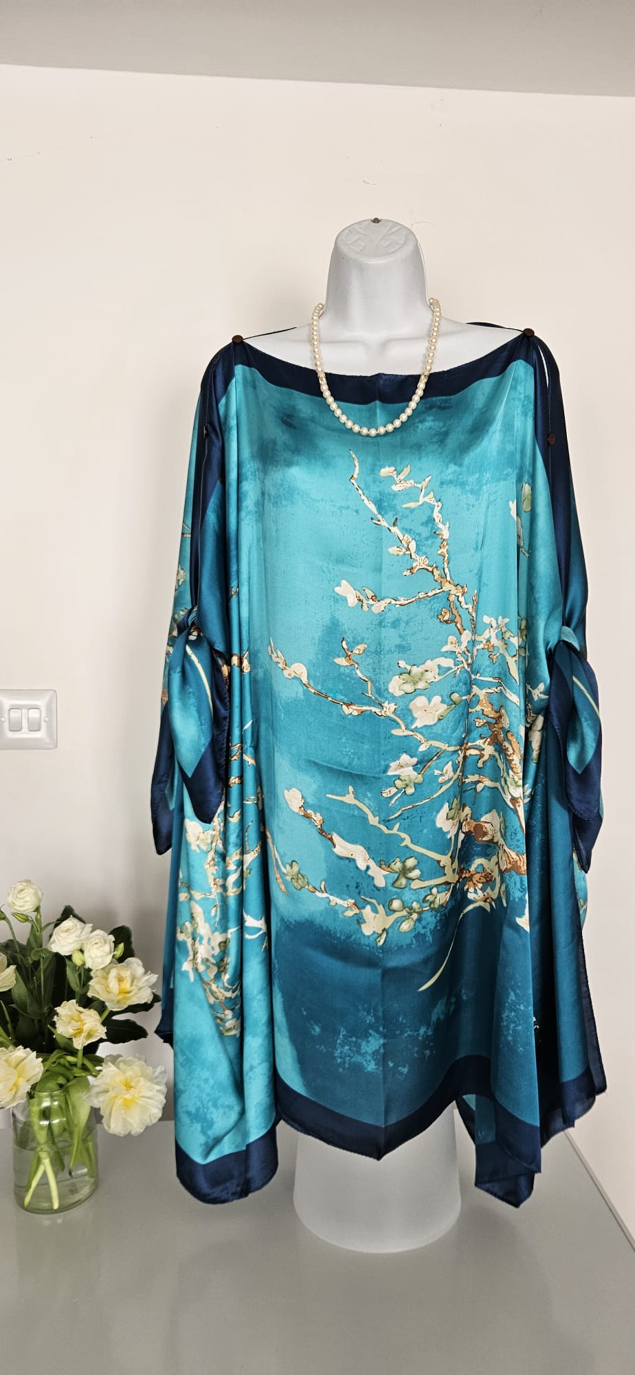 handmade boho-style multi-wear kaftan coloured with cherry blossom turquoise, with navy blue and botanical, made from a soft cotton-polyester blend  